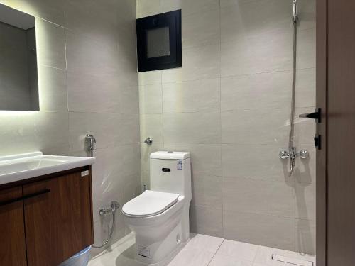 a bathroom with a toilet and a sink at أجنحة رافينا هاوس - Ravina Suites in Riyadh