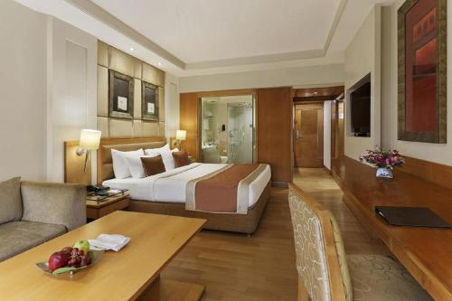 a hotel room with a bed and a living room at Hotel Royal Infinity Near Delhi Airport in New Delhi