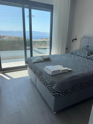 a bed in a bedroom with a large window at Villa Ant in Çeşme