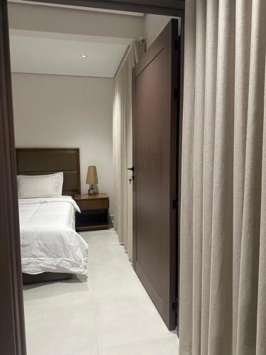 a bedroom with a bed and a sliding door at أجنحة رافينا هاوس - Ravina Suites in Riyadh