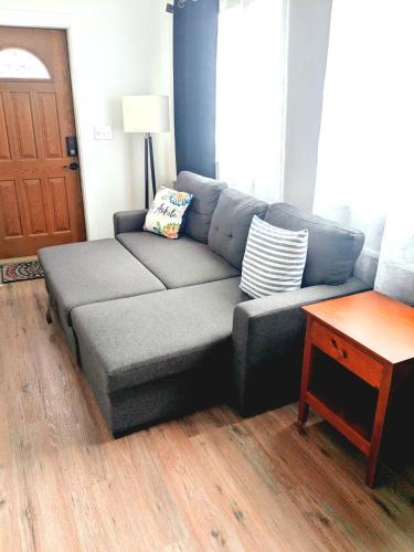 a gray couch in a living room with a table at Cozy Guesthouse in Catasauqua