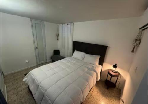 a bedroom with a large white bed and a table at Urban Oasis Hideaway in Fajardo