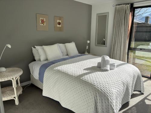 a bedroom with a large bed with a window at Chartres Retreat in Arrowtown