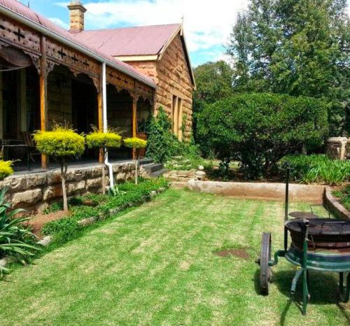 a house with a wheelbarrow in front of a yard at The Journey GuestHouse in Ladybrand