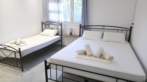 une chambre avec deux lits avec des serviettes dessus dans l'établissement MakaLand Studio Corfu, à Evropoúloi