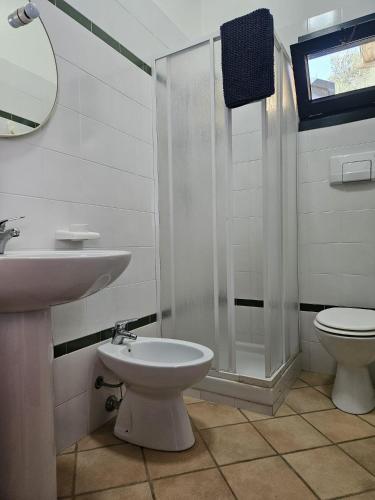 a bathroom with a sink and a toilet and a shower at Villetta Mari Pintau in Geremèas