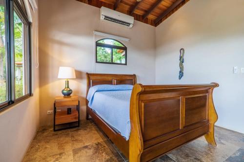 a bedroom with a wooden bed and a window at Getaway & Ocean Breeze - Secluded & Natural Charming - 2 bedrooms in Barú