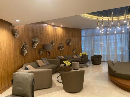 a living room with couches and chairs in a room at Hotel De Rama Unit 5115 near MOA and NAIA in Manila