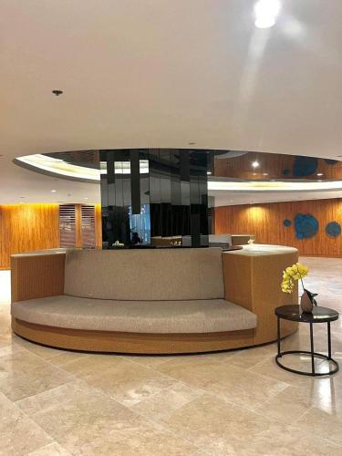 a large couch in a lobby with a table at Hotel De Rama Unit 5115 near MOA and NAIA in Manila