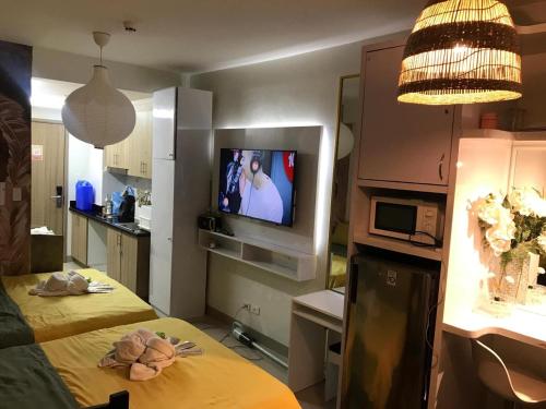 a room with two beds and a television in it at Hotel De Rama Unit 5115 near MOA and NAIA in Manila