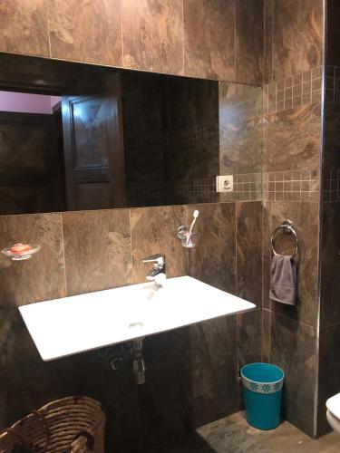 a bathroom with a white sink and brown tiles at Apartment Galia Mohammedia in Mohammedia