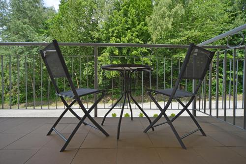 ヴィスワにあるApartamenty Sun Seasons 24 - Bukowaのバルコニー(椅子、テーブル付)