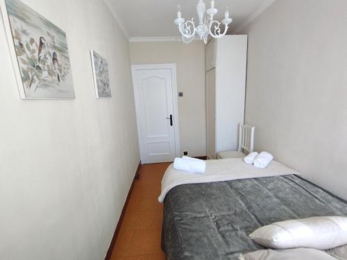 a bedroom with two beds and a chandelier at Apartamento La Luz de Reinosa 1 in Reinosa