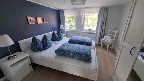 a bedroom with two beds with blue pillows at Ferienwohnung Achterdeck - Alte Schmiede Neugarmssiel in Wangerland