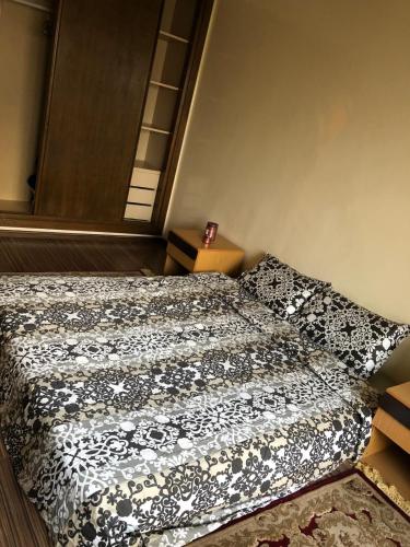 a bedroom with a bed with a black and white comforter at Apartment Galia Mohammedia in Mohammedia