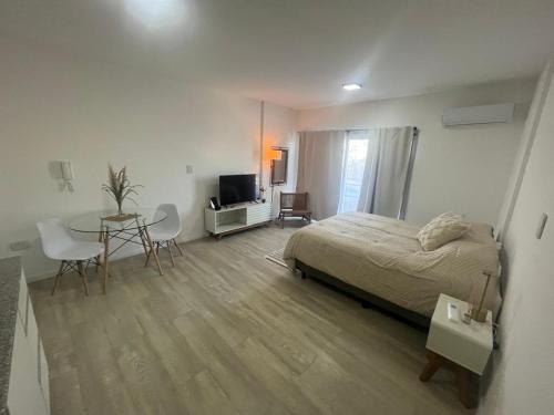 a bedroom with a bed and a table and a television at L&M Suite Monoambiente in Belén de Escobar