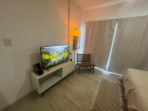 a bedroom with a flat screen tv and a bed at L&M Suite Monoambiente in Belén de Escobar