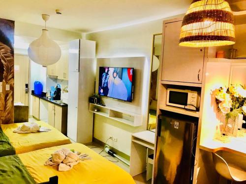a small room with two beds and a television at Hotel De Rama Unit 5115 near MOA and NAIA in Manila