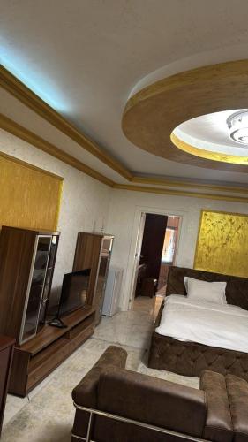 a bedroom with a bed and a couch and a tv at Hotel Premium in Pristina