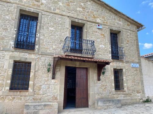 a stone building with a door and a balcony at Casa Rural Mas María in Horta de San Joan