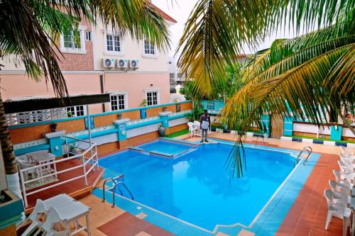 a large swimming pool with palm trees and a building at 5 Starvilla hotel Bed and Breakfast in Trofwi