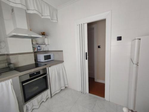 a kitchen with a stove and a microwave at Apartamento La Luz de Reinosa 1 in Reinosa
