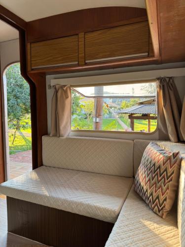 a seat in the back of an rv with a window at Trailer Vintage no Sítio Wanderlust in Rolante