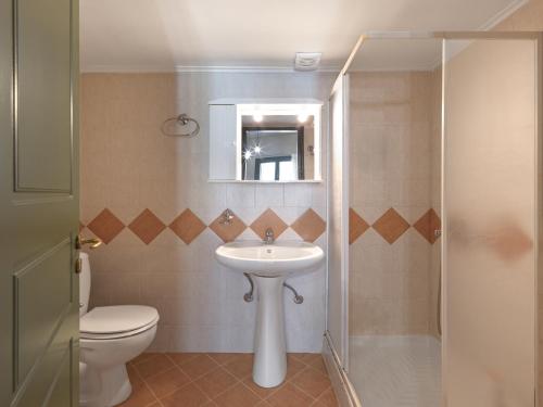 a bathroom with a sink and a toilet and a mirror at Luxury Studios & Cozy Apartments by White Hills in Arachova