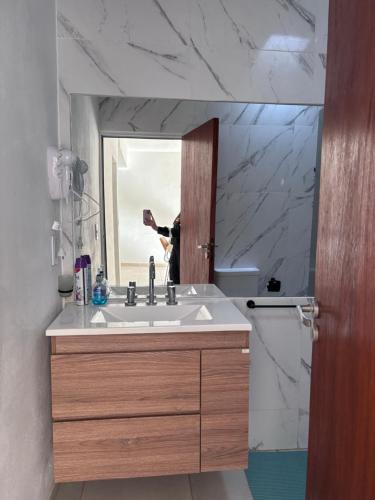 a person taking a picture of a bathroom sink at Casa hasta 6 personas in Villa María