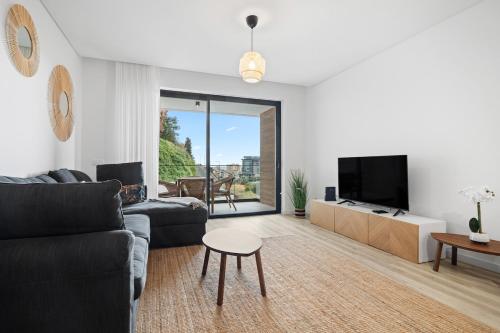 a living room with a couch and a tv and a table at MK Apart I in Funchal
