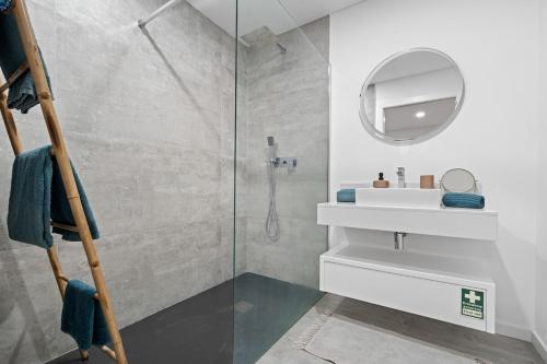 a bathroom with a shower and a sink and a mirror at MK Apart I in Funchal
