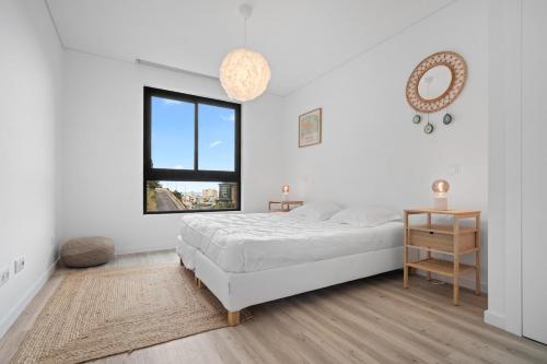 a white bedroom with a bed and a window at MK Apart I in Funchal