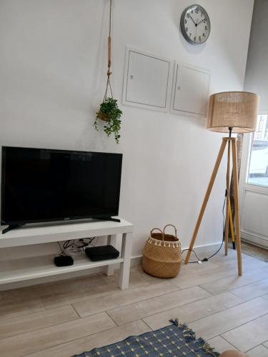 a living room with a flat screen tv on a white wall at Casa do Hilário in Viseu