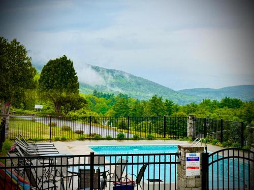 a swimming pool with a view of a mountain at Travelodge by Wyndham Lake George NY in Lake George
