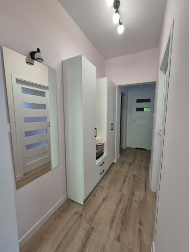 an empty hallway with white walls and wooden floors at Tarnów Zawada Apartament in Tarnów