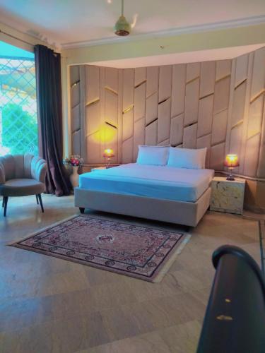 a bedroom with a king sized bed and a rug at Dazzy Dream Guest Houses in Islamabad