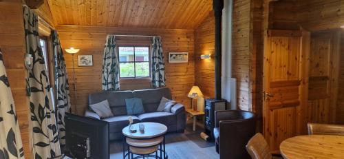 a living room with a couch and a table at Chalet Vechtdal, Plus Sauna in Gramsbergen