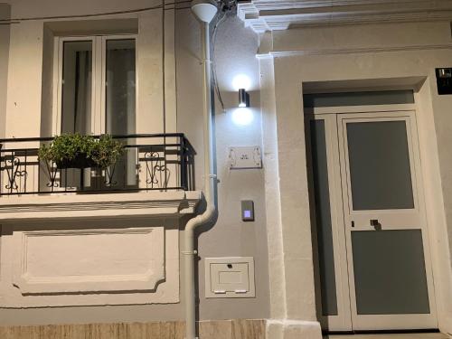 a building with a door and a balcony with a plant at Apa Sicula in Avola