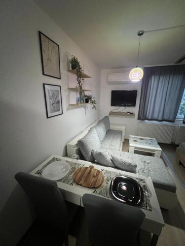 a small living room with a table and a couch at Firefly Studio Apartment in Sarajevo