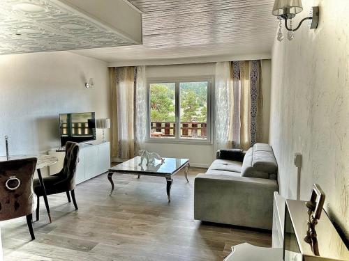 a living room with a couch and a table at White dream in Gréolières les Neiges