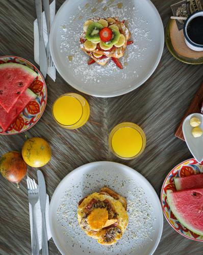 two plates of food on a table with fruit at Kawa Bamboo Retreat in Pereira