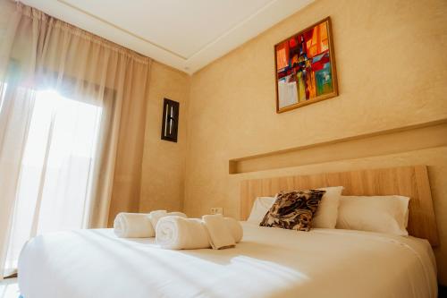 a bedroom with two beds with white sheets and a window at The Ocean Surf Villa in Dakhla