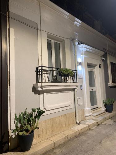 a balcony on the side of a building with potted plants at Apa Sicula in Avola