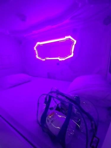 a neon sign sitting on a bed in a room at MOONOTEL Maidan in Kyiv