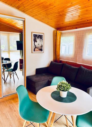 a living room with a table and chairs at Leśna Przystań in Pobierowo