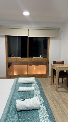 a room with a bed with three towels on it at Hospedaje La Angostura in Ica