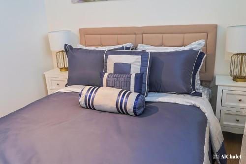 a bed with blue and white pillows on it at Artiste B - Esquisse Moderne in Wendake