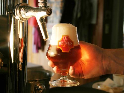 a person holding a glass of beer at a brewery at Brauereigasthof Reiner in Lochau