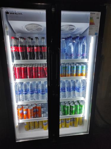 an open refrigerator filled with bottles of water and soda at Merzouga Desert Experience Camp-Erg Chebbi Sunset & Camel Ride in Merzouga