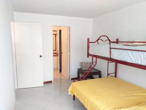 a bedroom with two bunk beds and a yellow mattress at PARAJISO en Costa Azul in Porlamar
